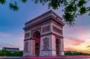 The Arc de Triomphe at sunset under a pink sky