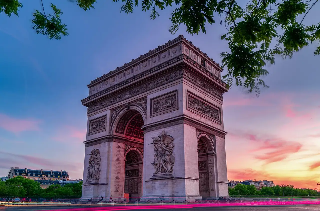 The Arc de Triomphe at sunset under a pink sky