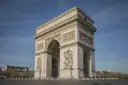 The Arc de Triomphe seen at an angle under a clear blue sky