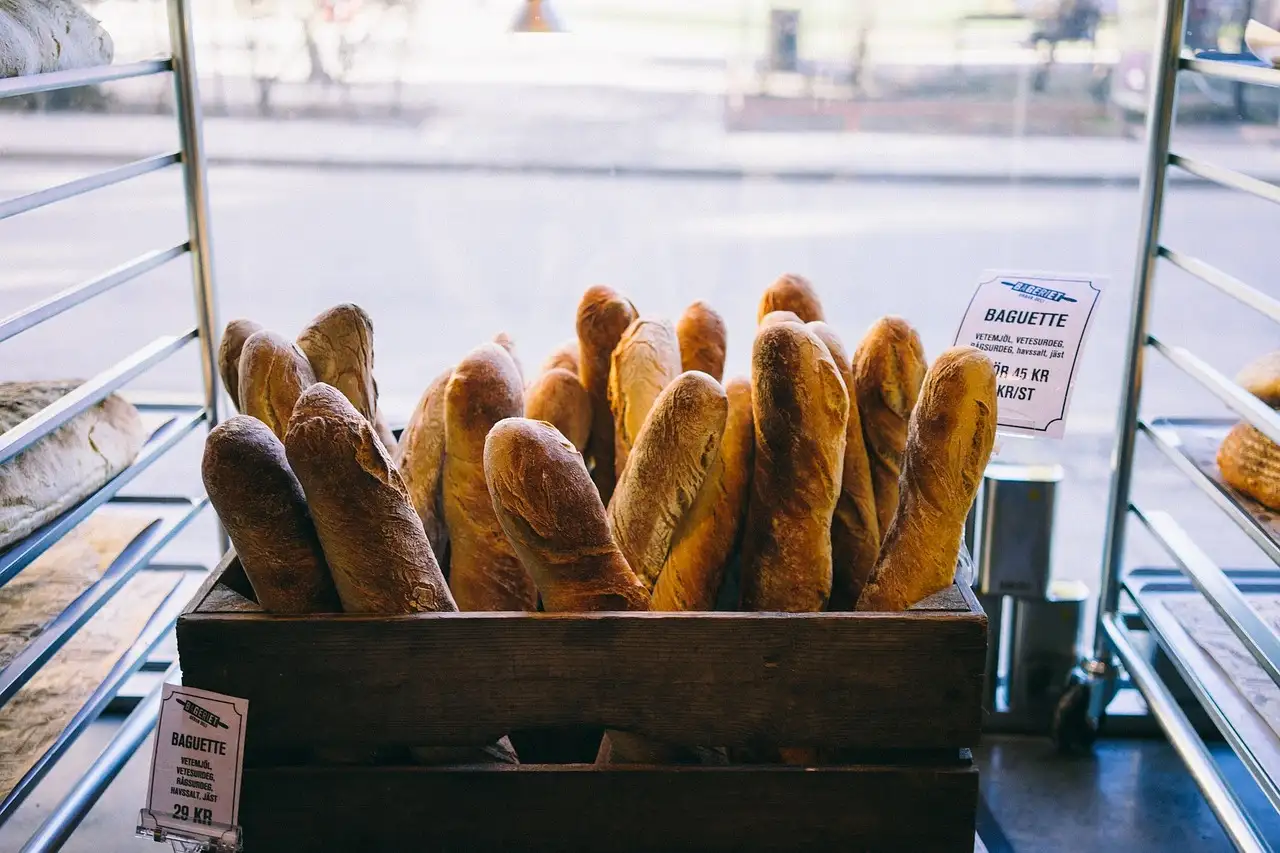 Baguettes standing in a wooden crate in a bakery window