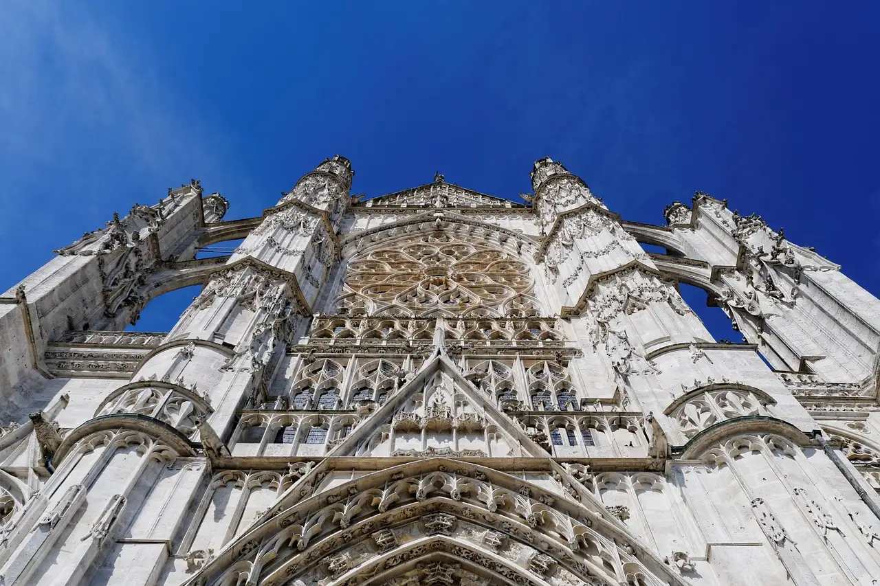 The tall Gothic facade of Beauvais cathedral against a blue sky