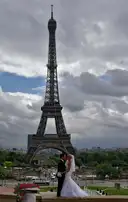 A bride and groom posing at the Trocadéro, the Eiffel Tower behind them