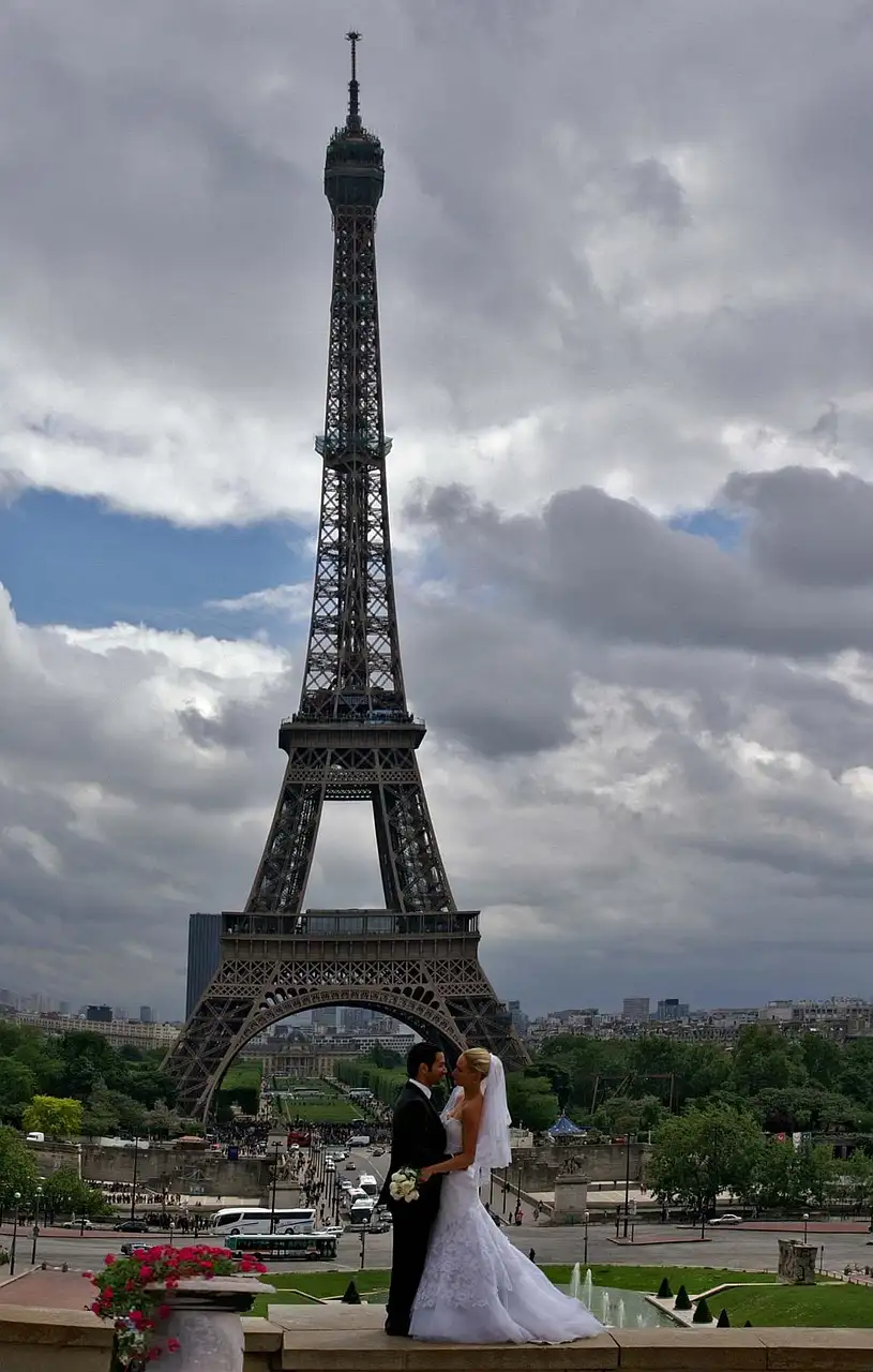 A bride and groom posing at the Trocadéro, the Eiffel Tower behind them