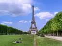 The Eiffel Tower beyond the Champ de Mars lawns on a sunny day