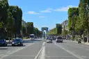 The wide Champs-Élysées on a summer day, the Arc de Triomphe at the far end