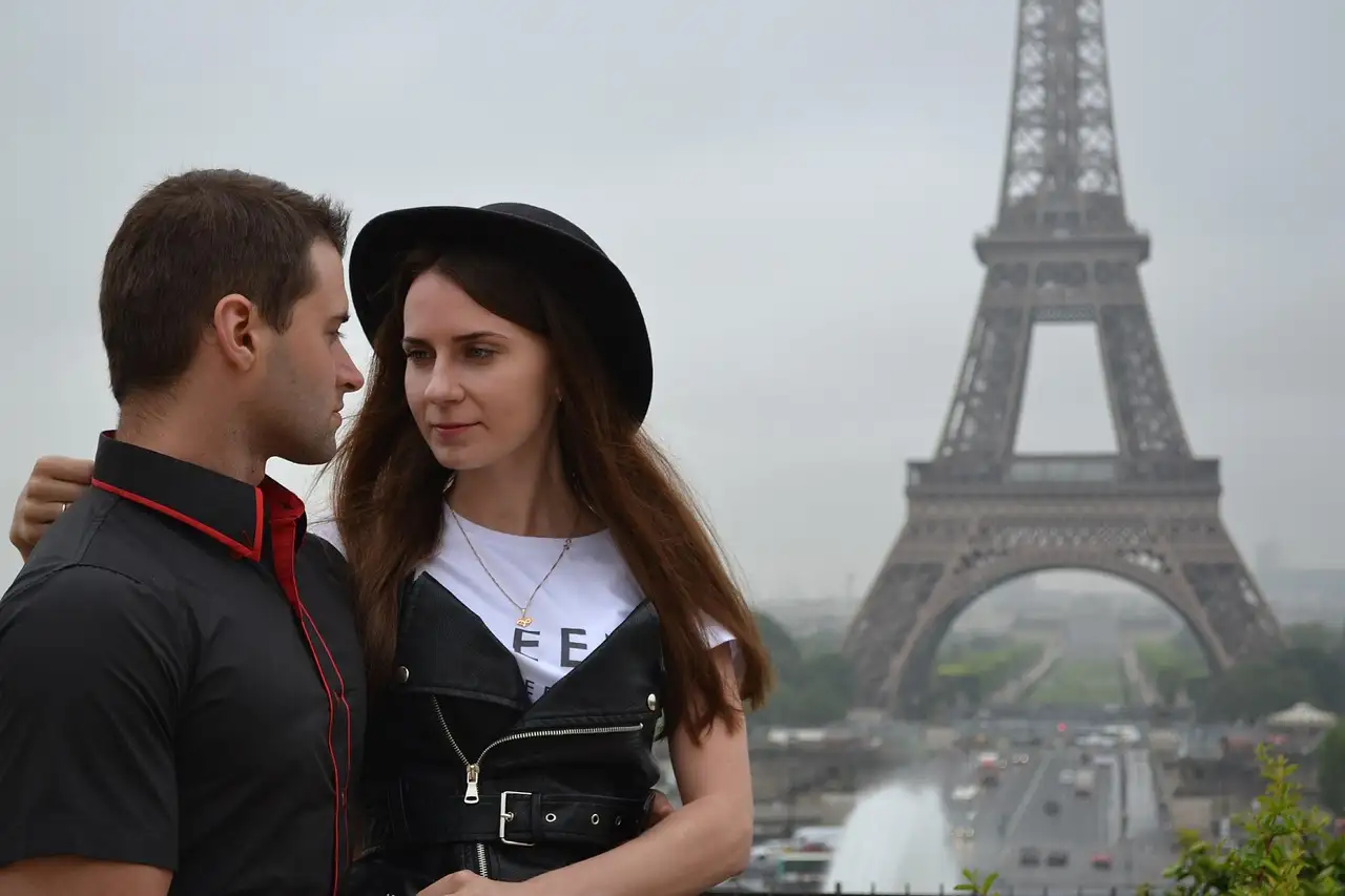 A couple posing at the Trocadéro, the Eiffel Tower behind them