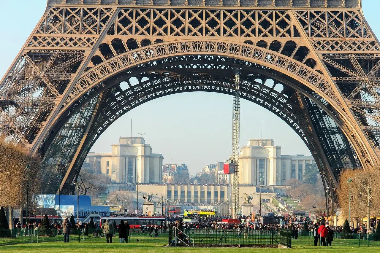 The base of the Eiffel Tower framing the Trocadéro on a sunny day