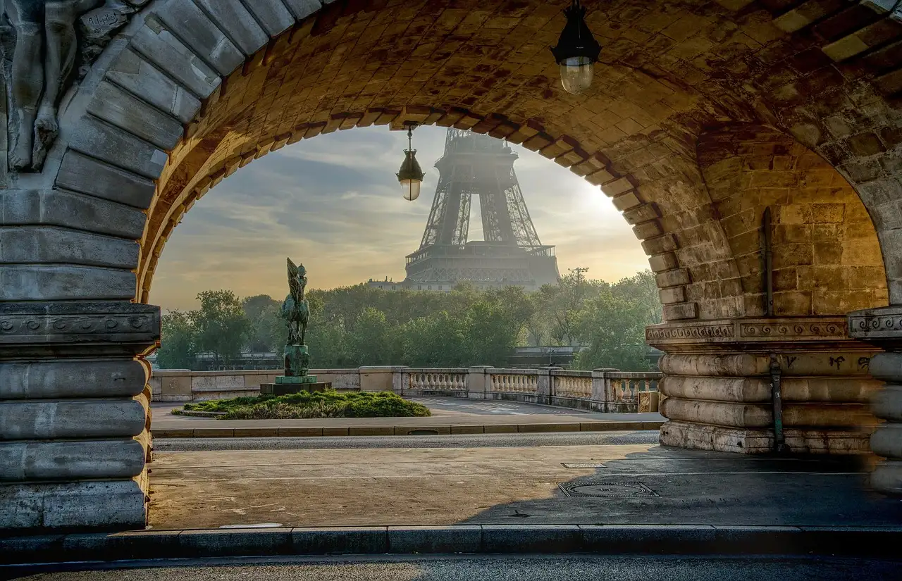 The Eiffel Tower framed by a stone arch of the Bir-Hakeim bridge