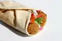 A falafel wrap with tomato and herbs in flatbread