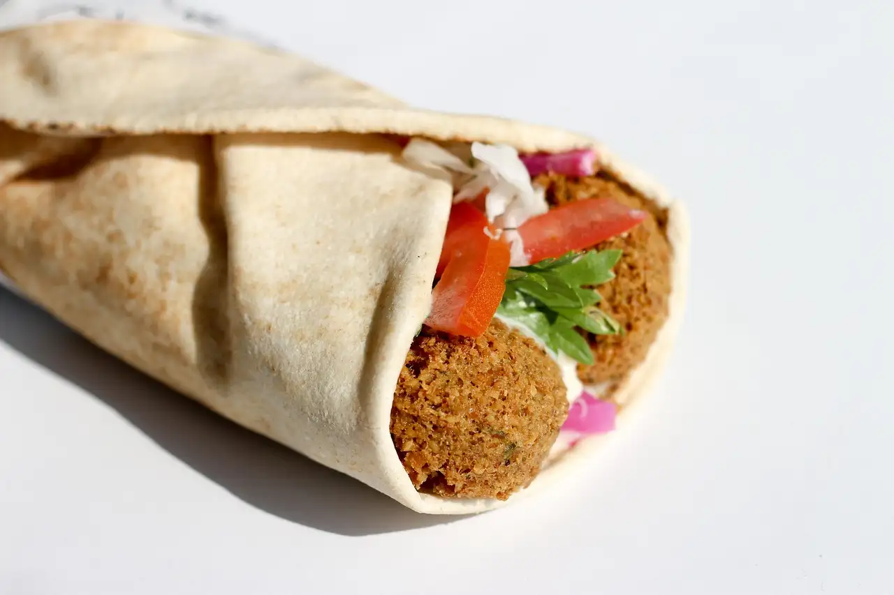 A falafel wrap with tomato and herbs in flatbread