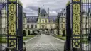 The Château de Fontainebleau through its open gilded gates, across the cobbled courtyard