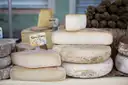 Wheels and blocks of French cheese stacked on a cheese counter