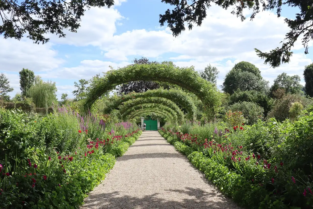 The gravel Grande Allée under rose arches in Monet's garden at Giverny