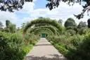 The gravel Grande Allée under rose arches in Monet's garden at Giverny