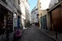 A narrow cobbled street in the Latin Quarter with bicycles parked by the wall