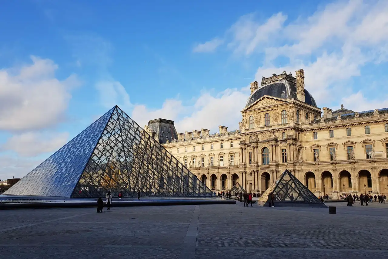 The Louvre glass pyramid and palace on a sunny day