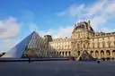 The Louvre glass pyramid and palace on a sunny day