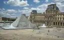 The Louvre glass pyramid and palace courtyard on a sunny day