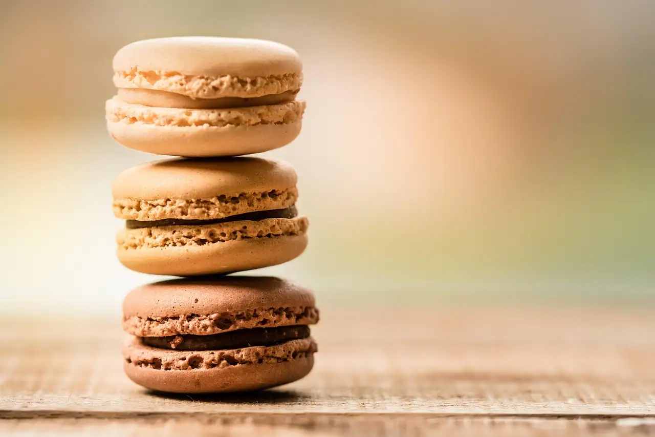 A stack of three macarons on a wooden table
