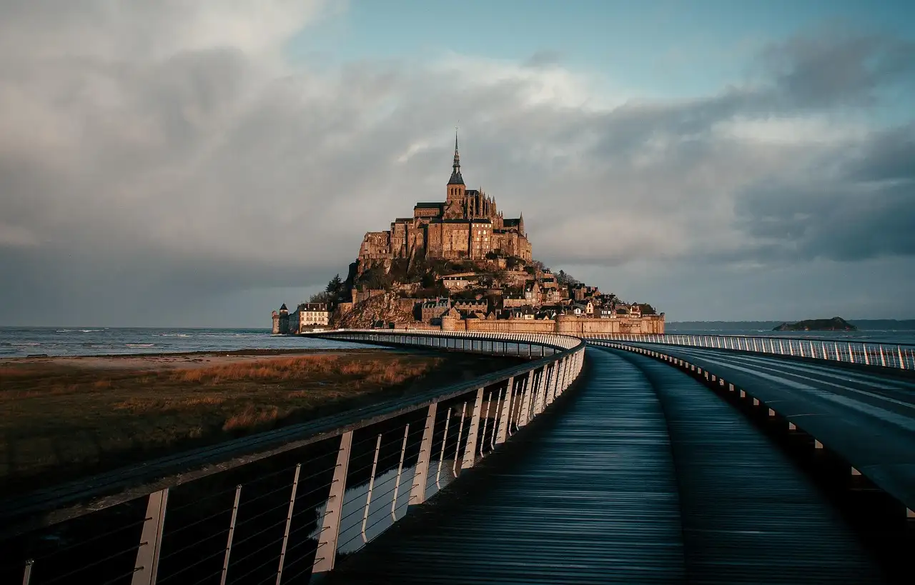The footbridge leading across the bay to Mont-Saint-Michel under heavy clouds