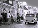 A Citroën 2CV on a Montmartre street next to street musicians