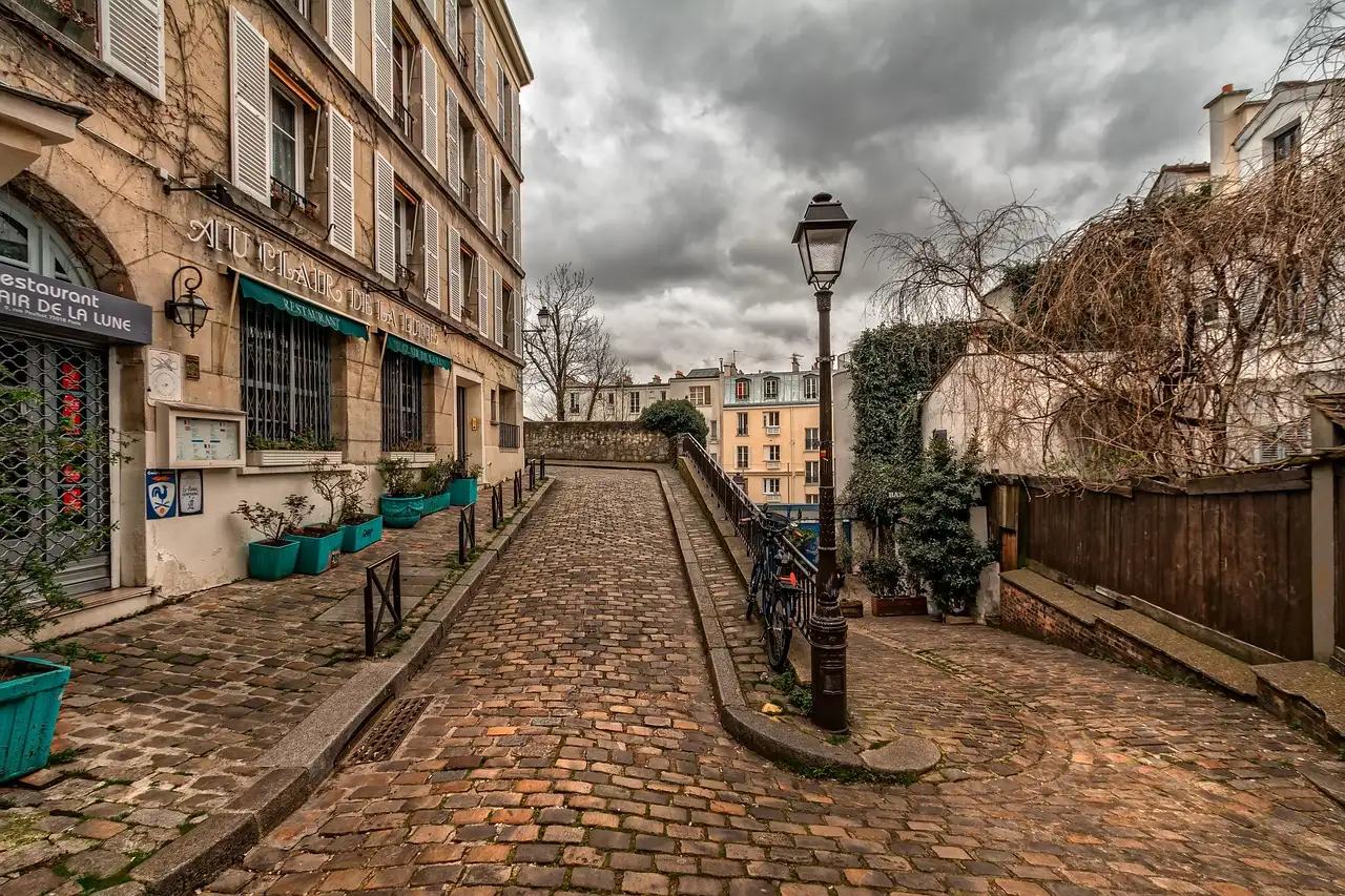 A cobbled Montmartre lane with an old street lamp and stone houses