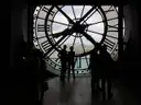 Visitors in silhouette behind the clock window of the Musée d'Orsay