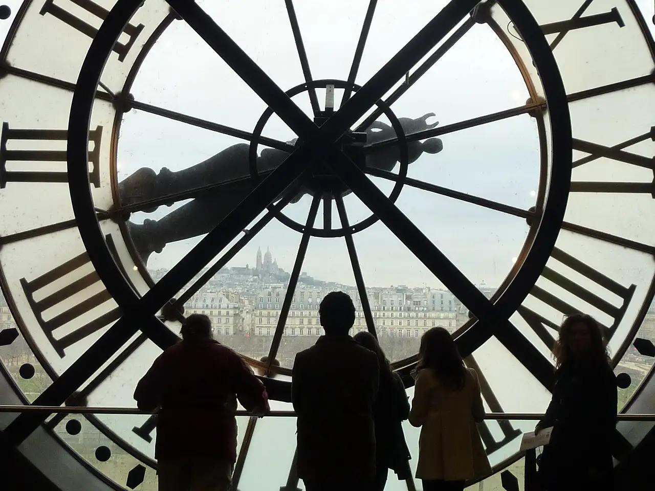 Visitors in silhouette behind the Musée d'Orsay's giant clock-face window