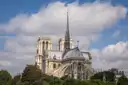 The back of Notre-Dame Cathedral with its spire above the trees