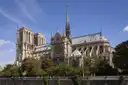 Notre-Dame Cathedral and its spire seen across the Seine on a sunny day