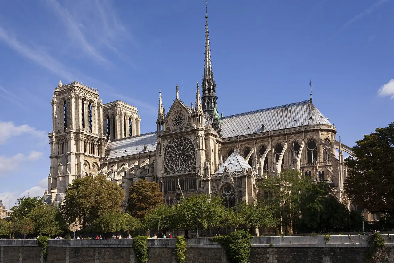 Notre-Dame Cathedral and its spire seen across the Seine on a sunny day