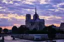 Notre-Dame in silhouette above the Seine at sunset