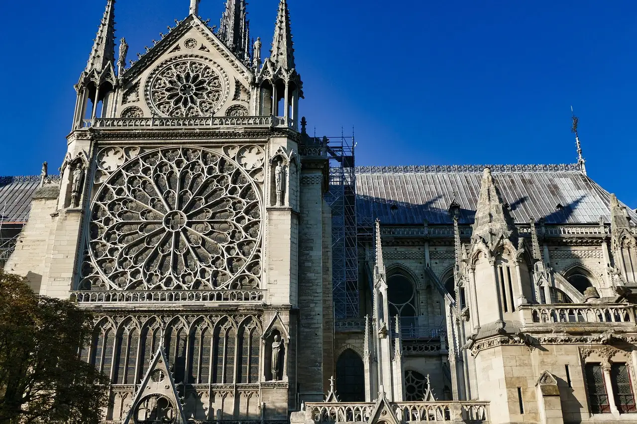 The south rose window and transept of Notre-Dame against a blue sky