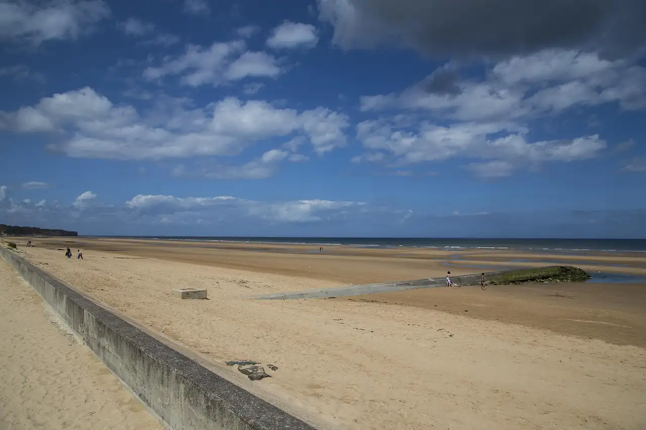The wide sandy shore of Omaha Beach in Normandy on a clear day