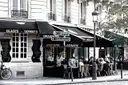 A Paris brasserie on a street corner with its terrace tables and awnings