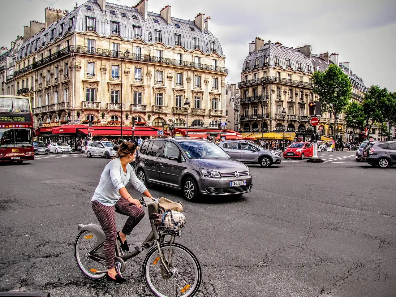 A cyclist crossing a cobbled Paris junction lined with Haussmann buildings