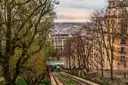 A Montmartre hillside with bare trees, the funicular tracks and Paris rooftops beyond