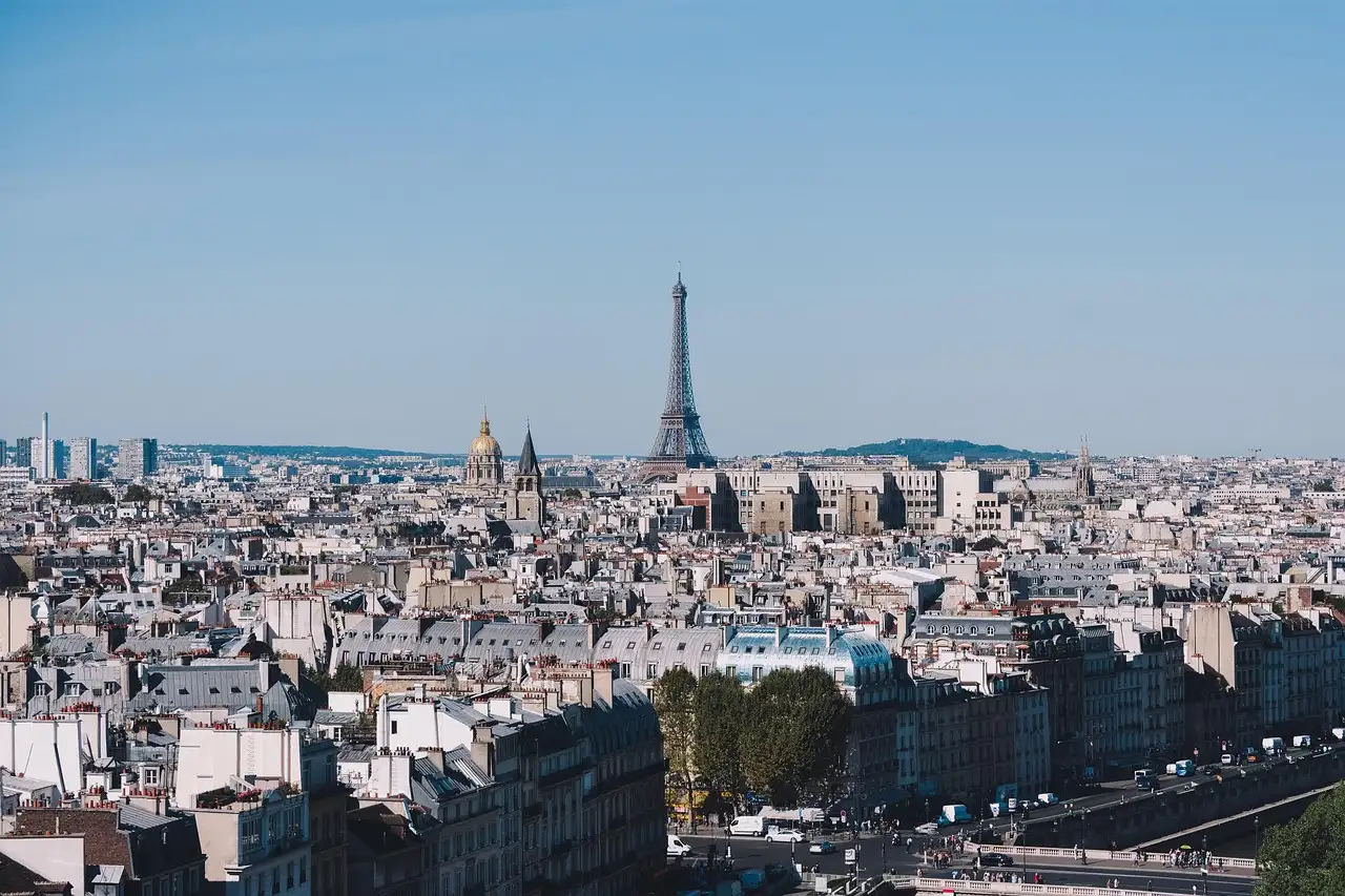 A wide view across Paris rooftops to the Eiffel Tower on a clear day