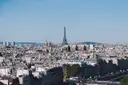 A wide view across Paris rooftops to the Eiffel Tower on a clear day