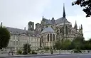 The Gothic cathedral of Reims rising behind a stone building and trees