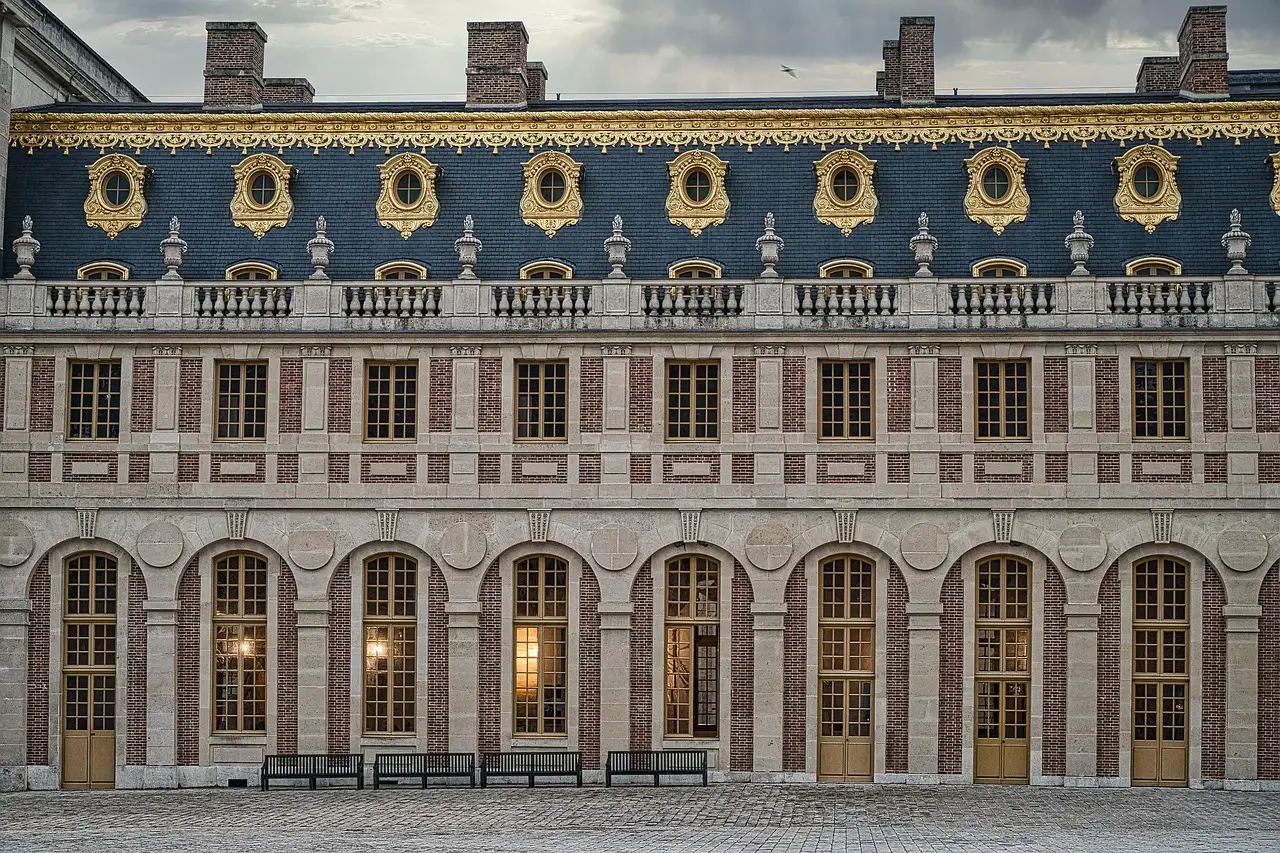 The slate-roofed brick and stone courtyard front of the Palace of Versailles