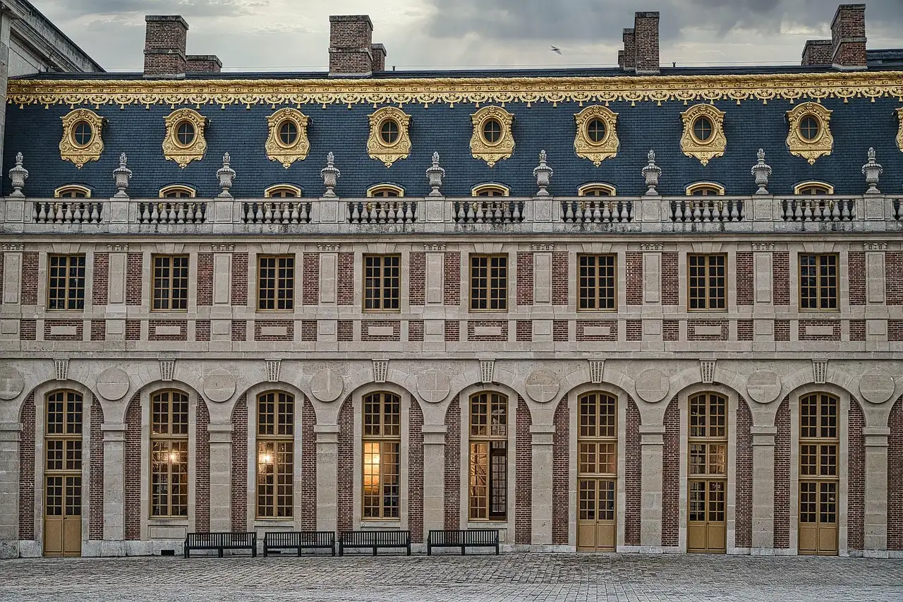 The slate-roofed brick and stone courtyard front of the Palace of Versailles