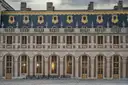 The slate-roofed brick and stone courtyard front of the Palace of Versailles