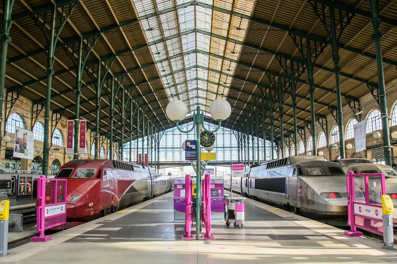 Trains standing under the iron and glass roof of the Gare du Nord hall in Paris