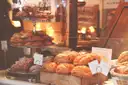 A pâtisserie counter with croissants, pastries and cakes on stands