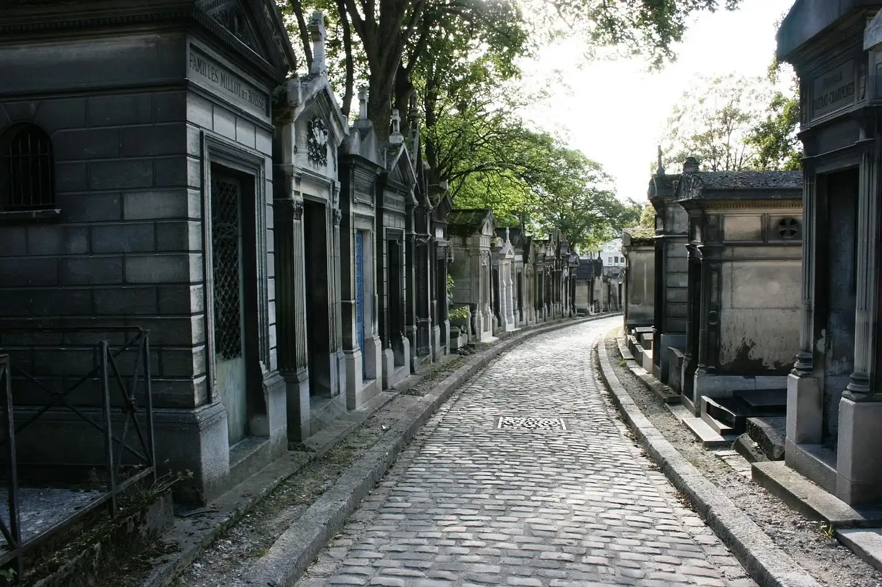 A cobbled avenue lined with stone tombs in Père Lachaise Cemetery