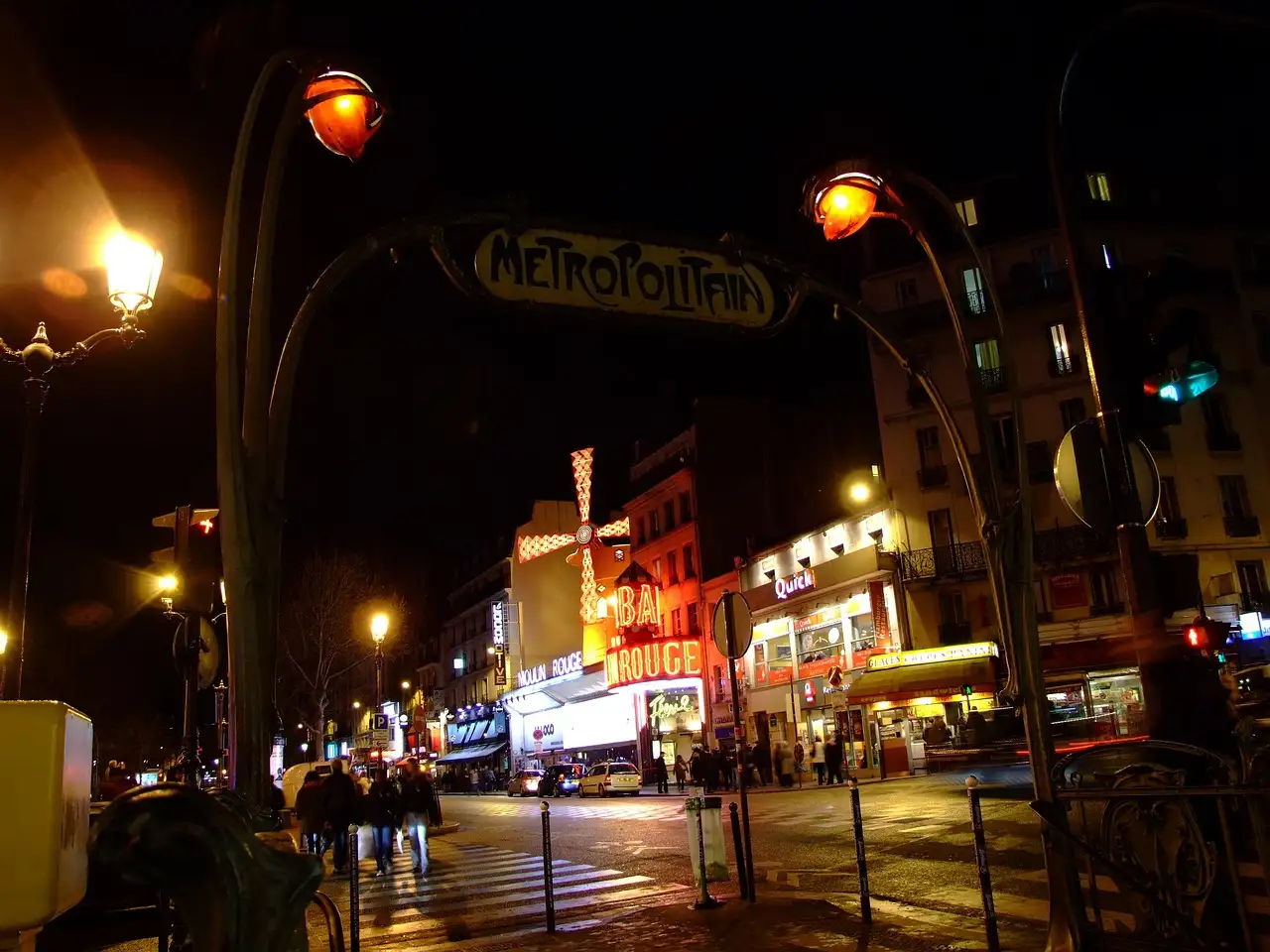 Boulevard de Clichy at night, with the lit Moulin Rouge further down the street