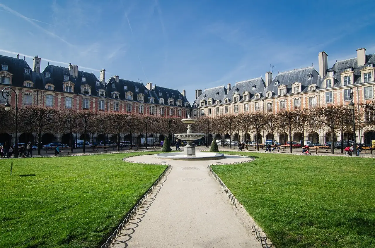 The Place des Vosges in the Marais, lawns and a fountain framed by red-brick houses