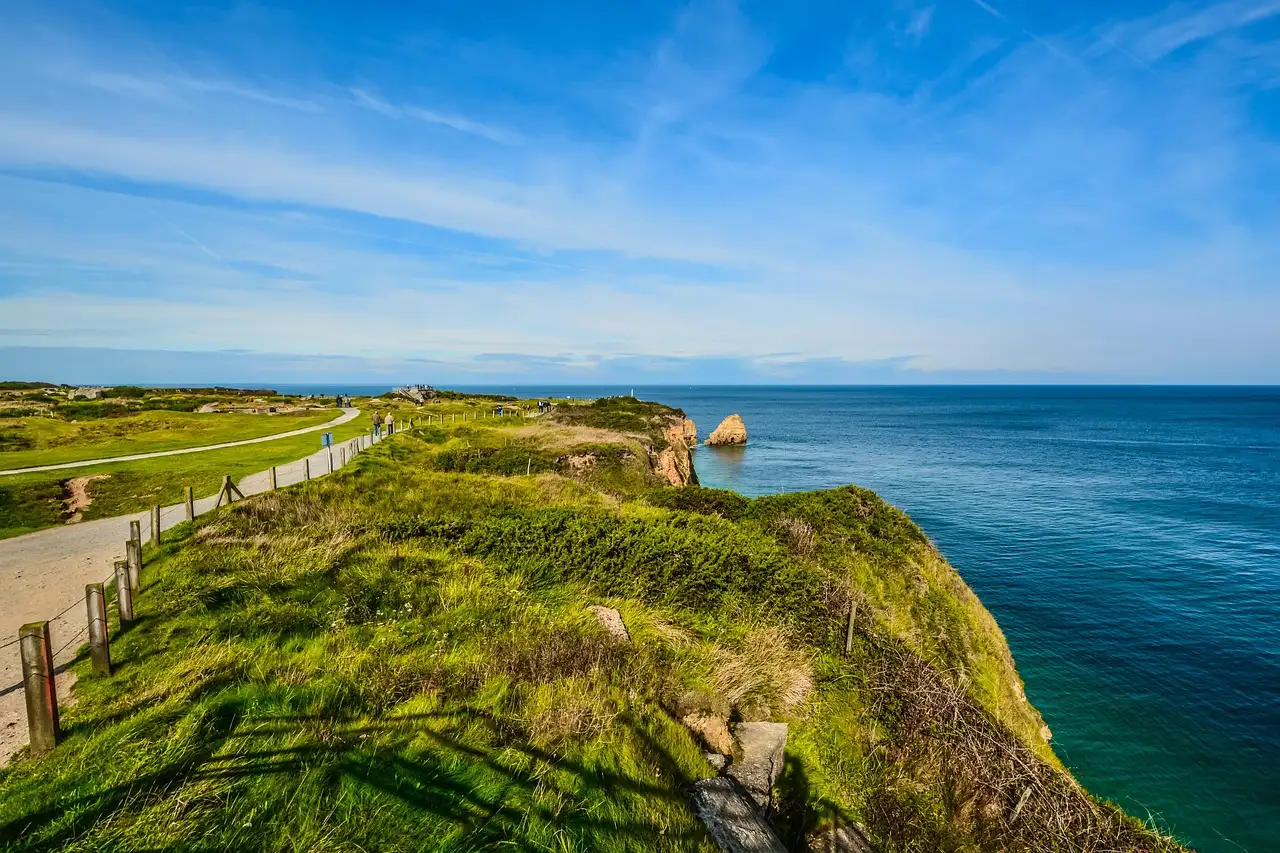 The grassy clifftop of Pointe du Hoc above the blue sea of the English Channel