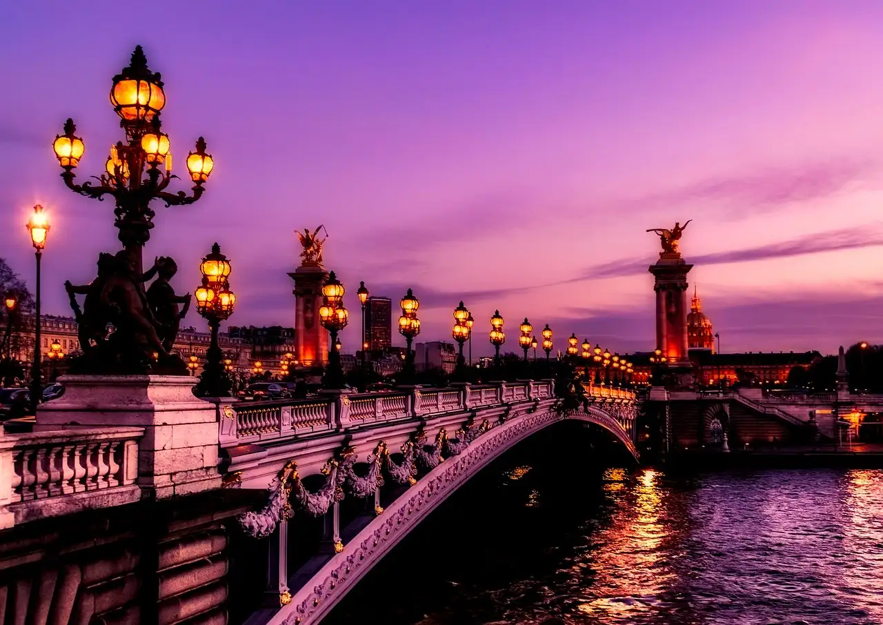 The lamps of Pont Alexandre III glowing over the Seine at dusk